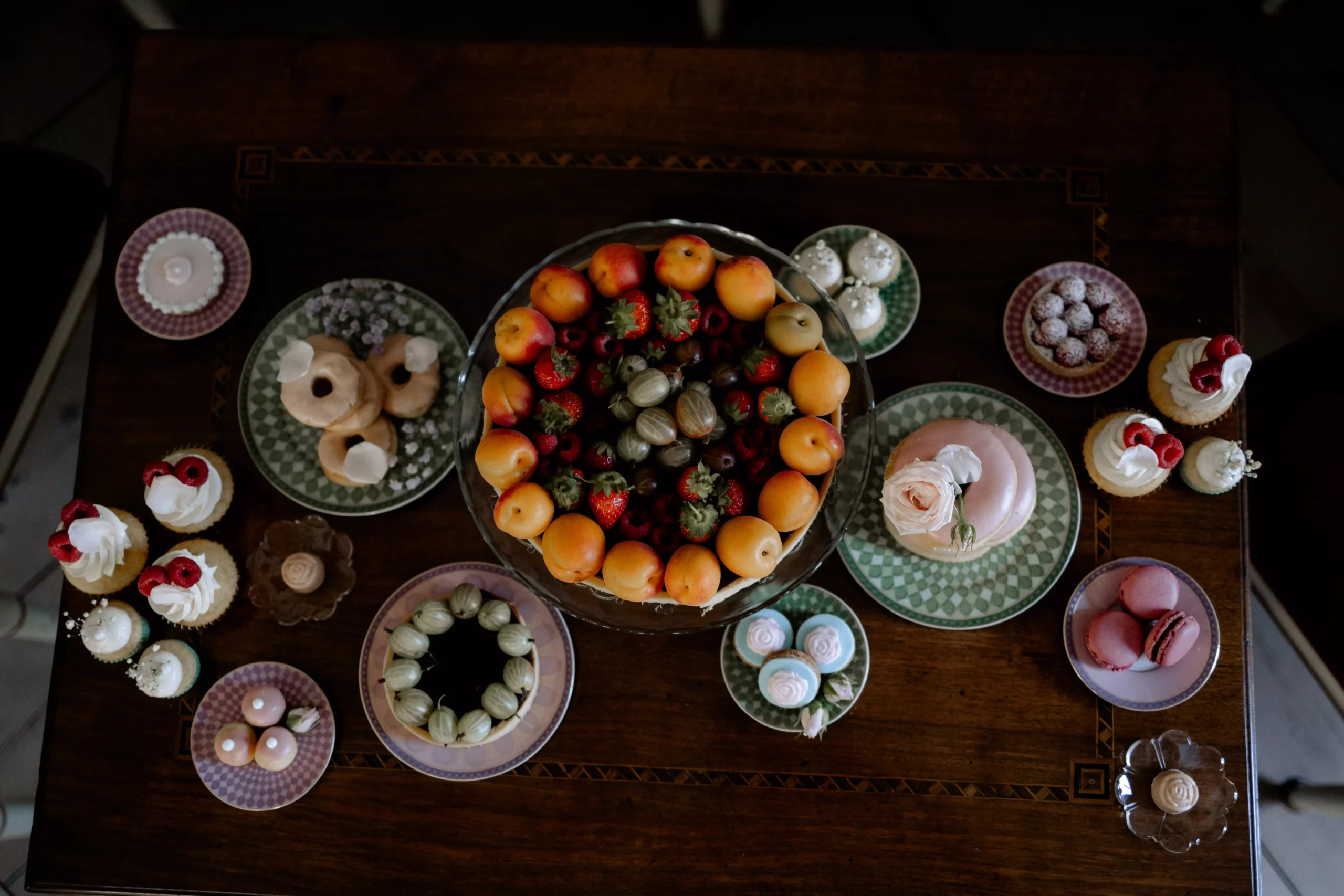 Eleganter Sweet Table mit Pralinen, Mini-Törtchen und goldenen Dekoelementen für exklusive Hochzeit oder Event.